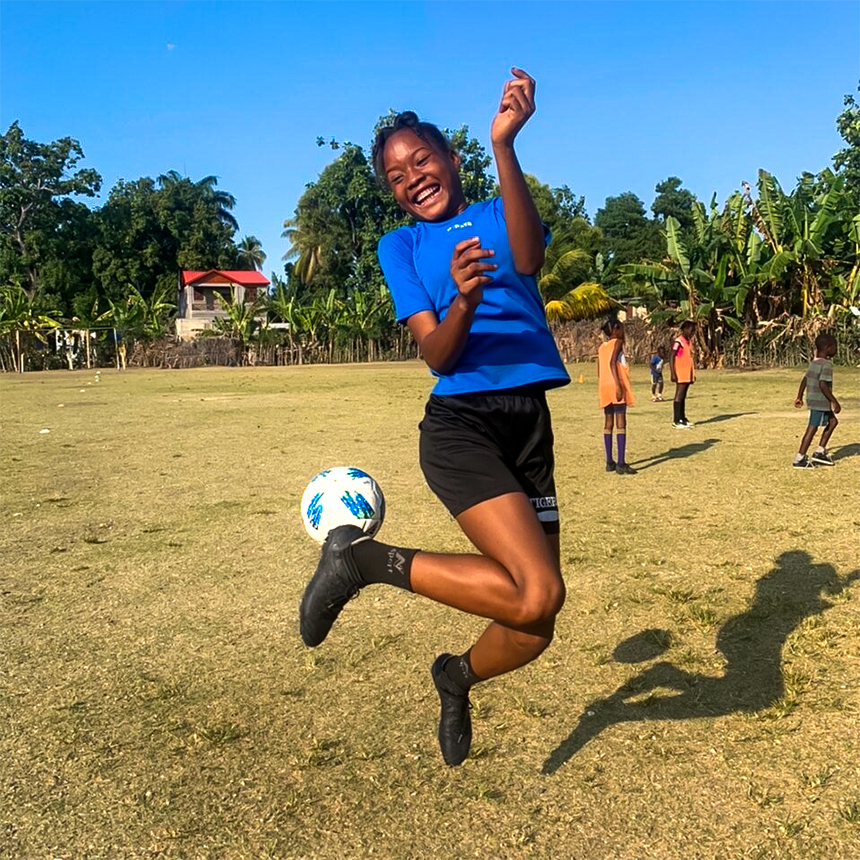 Haitian girl playing with soccer ball