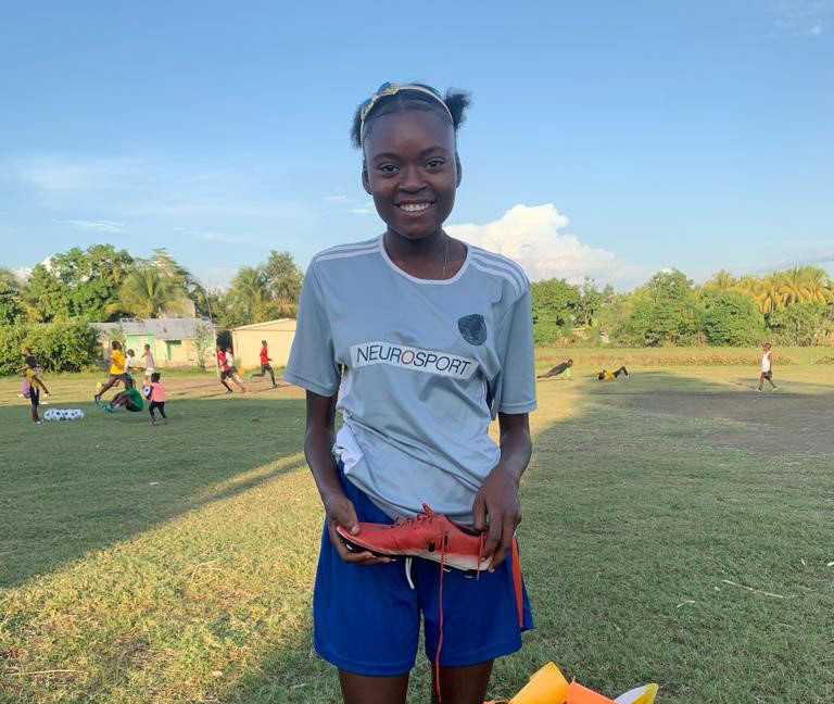 Girl smiling holding cleats