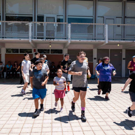 Coach leads warm-up activity with kids