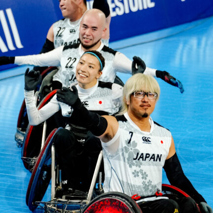 Wheelchair rugby players waving to crowd