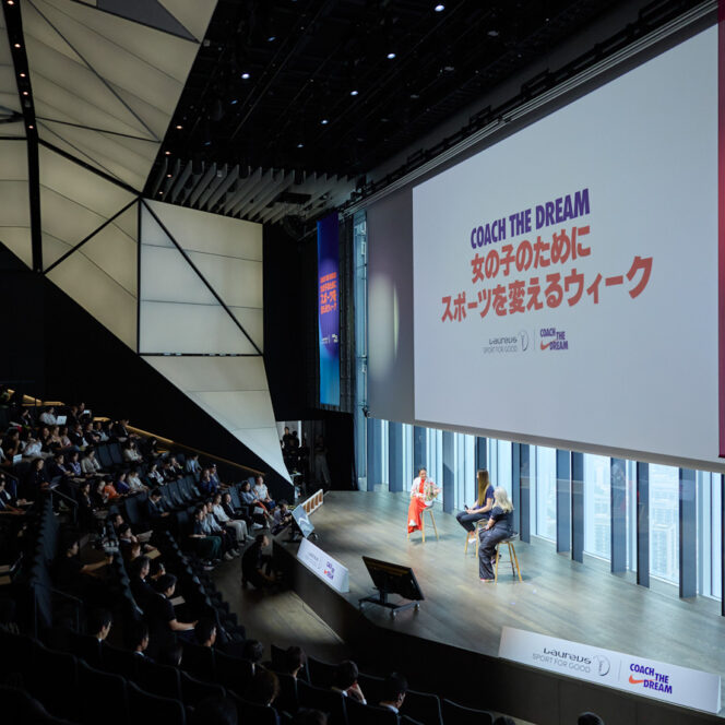 Stage scene of panel discussion with crowd.