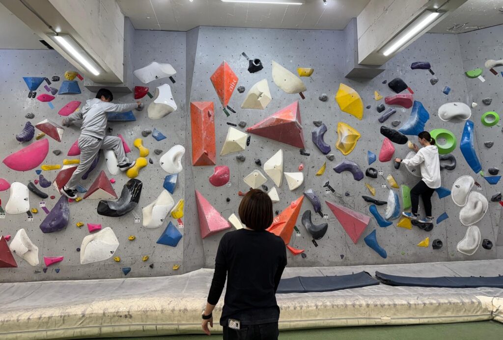 Coach giving directions to participant on a climbing wall